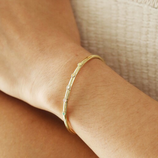 Model Wearing Adjustable Enamel Daisy Bangle in Gold