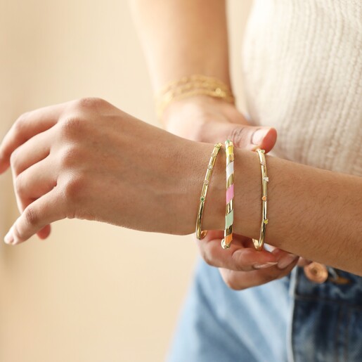 Model Wears Colourful Enamel Striped Bangle in Gold With Other Necklaces