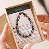 Model Holding Be Fearless Semi-Precious Stone Beaded Bracelet in Green in Box With Information Card on Potential Healing Properties