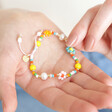 Model holding Colourful Flower and Pearl Beaded Bracelet in palm of hand