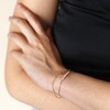 Model wearing Freshwater Seed Pearl Double Chain Bracelet in Gold with hand on arm