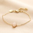 Gold Stainless Steel Semi-Precious Pink Aventurine Stone Bracelet on neutral coloured fabric