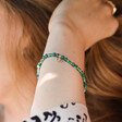 Close Up of Green Semi-Precious Beaded Bracelet with Sun Charm in Gold on Model