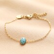 Semi-Precious Turquoise Stone Bracelet in Gold on beige coloured fabric