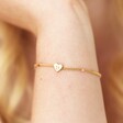 Close up of Smiling Heart Face and Enamel Ball Chain Bracelet in Gold on model