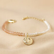 Talisman Moon Charm Pink and Pearl Beaded Bracelet in Gold on Neutral Fabric