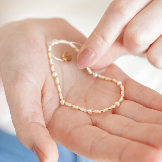 Model holding White Miyuki Bead and Freshwater Seed Pearl Bracelet in palm of hand