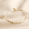 White Miyuki Bead and Freshwater Seed Pearl Bracelet on beige coloured fabric