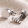 Brushed Finish Round Cufflinks in Silver One Showing Toggle Fastening on Beige Fabric