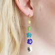 close up of Asymmetrical Millefiori Flower Bead Drop Earrings on model