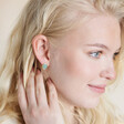 model smiling wearing Blue Oval Semi-Precious Stone Stud Earrings in Gold hand on neck
