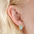 Close up of Blue Oval Semi-Precious Stone Stud Earrings in Gold on model