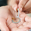 Model Holding Blue Stone Hoop Earrings in Gold in Palm of Hand