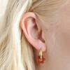 Close Up of Brick Red Resin Flower Huggie Hoop Earrings in Gold on Model