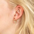 Close up of blonde model wearing the Colourful Enamel Pom Pom Huggie Hoop Earrings in Gold