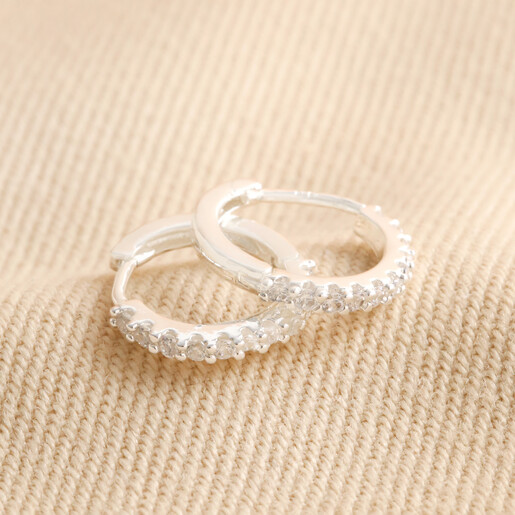 Crystal Huggie Hoops in Silver on beige Fabric