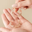 Model Holding Dried Flower Resin Hoop Earrings in Pink