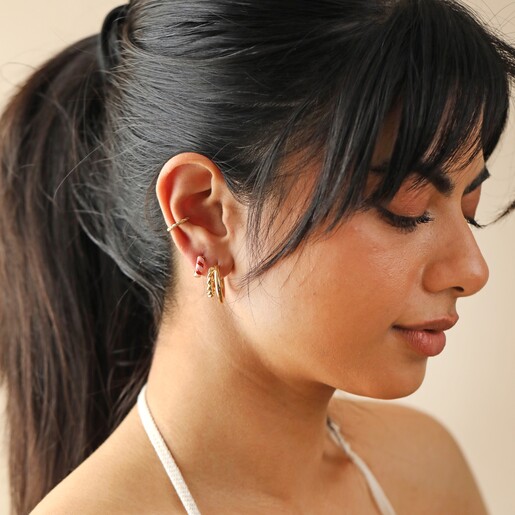 Model Wearing Enamel Striped Huggie Hoop Earrings in Red and Pink With Other Hoops