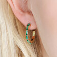Close up of model wearing Green Baguette Crystal Hoop Earrings in Gold