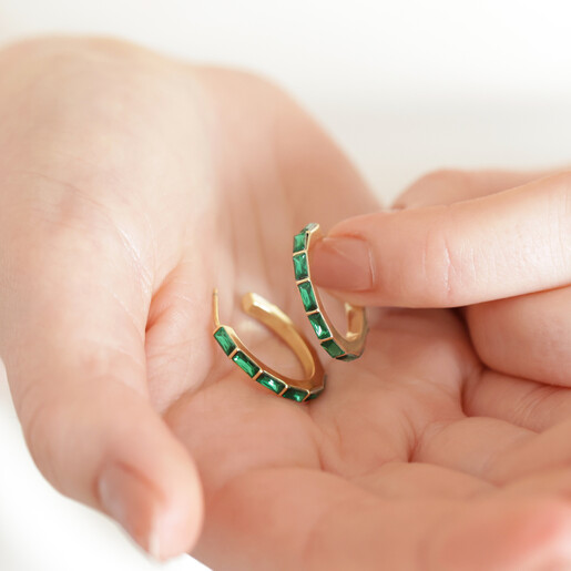model holding Green Baguette Crystal Hoop Earrings in Gold in palm of hand