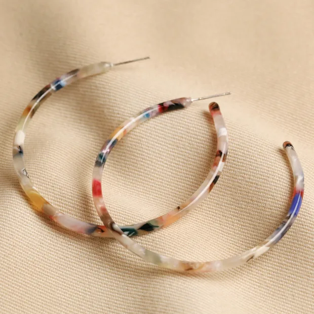 Hoops Earrings on Fabric Large Tortoiseshell Resin Hoop Earrings in Rainbow on Beige Fabric