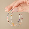 Model Holding Large Tortoiseshell Resin Hoop Earrings in Rainbow