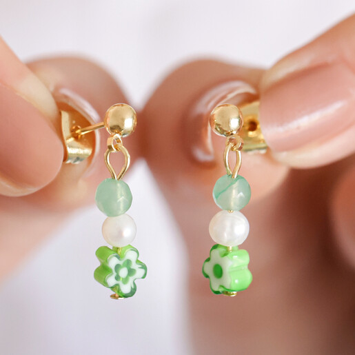 Model Holding Millefiori Green Flower Drop Earrings in Gold in Front