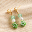 Millefiori Green Flower Drop Earrings in Gold on Beige Coloured Material