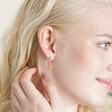 Model wearing Millefiori Heart and Flower Drop Earrings in Gold with hand behind ear