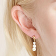Close up of Millefiori White Flower Drop Earrings in Gold on model