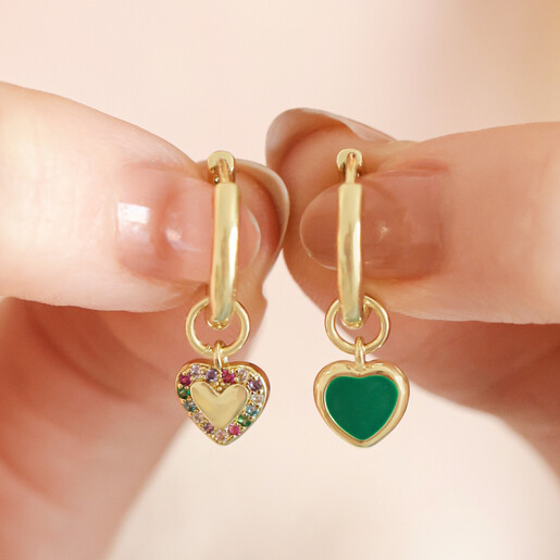 Model holding Mismatched Crystal Enamel Heart Huggie Hoops in Gold in front