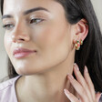 Model Wearing Pink Cloisonné Hoop Earrings in Gold with Hand on Neck