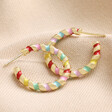 Rainbow Enamel Twist Hoop Earrings in Gold on Neutral Fabric