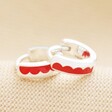 Close Up of Red Enamel Scalloped Huggie Hoop Earrings in Silver on Neutral Fabric