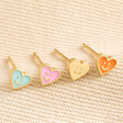 Set of 4 Mismatched Heart Face Stud Earrings in Gold on beige coloured fabric