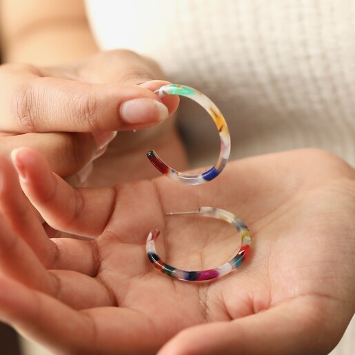 Model Holding Tortoiseshell Resin Hoop Earrings in Rainbow