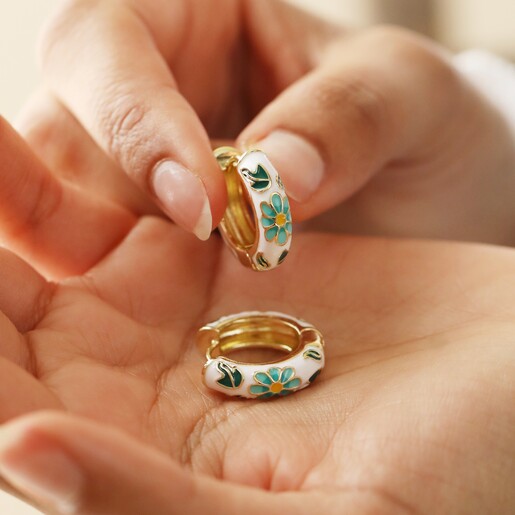 Model Holding White Cloisonné Hoop Earrings in Gold in Palm of Hand