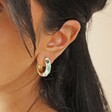 Close Up of White Cloisonné Hoop Earrings in Gold on Model