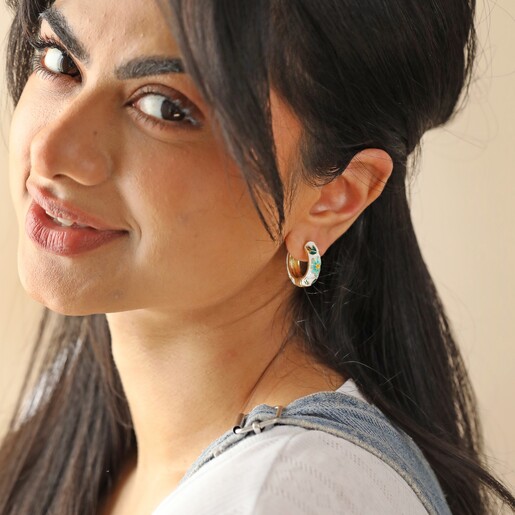 Model Looking at Camera Wearing White Cloisonné Hoop Earrings in Gold