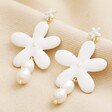 White Enamel and Pearl Daisy Drop Earrings in Gold on Neutral Fabric