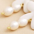 Close Up of Pearls on White Enamel and Pearl Daisy Drop Earrings in Gold