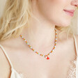 Model looking to side wearing Colourful Pearl and Tassel Beaded Necklace in Gold 