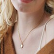 Close Up of Personalised Birth Flower Crystal Edge Pendant Necklace in Gold on Model