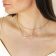 Gold Stainless Steel Pink Aventurine Half Circle Pendant Necklace on dark haired model with curated look