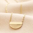 Close up of pendant on Gold Stainless Steel Pink Aventurine Half Circle Pendant Necklace on beige material