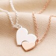 Mother & Child Set of 2 Heart Puzzle Necklaces in Silver and Rose Gold Linked Together on Beige Fabric