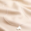 Heart Puzzle Necklace in Silver from the Mother & Child Set of 2 Heart Puzzle Necklaces in Silver and Rose Gold on Beige Fabric