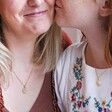 Daughter Kissing Mother's Cheek While Both Wearing Mother & Child Set of 2 Sun and Moon Necklaces in Gold
