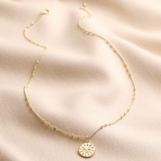 Sun Necklace from the Mother & Child Set of 2 Sun and Moon Necklaces in Gold on Beige Fabric