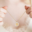 Model holding Personalised Birth Flower Crystal Edge Pendant Necklace in Gold between fingers